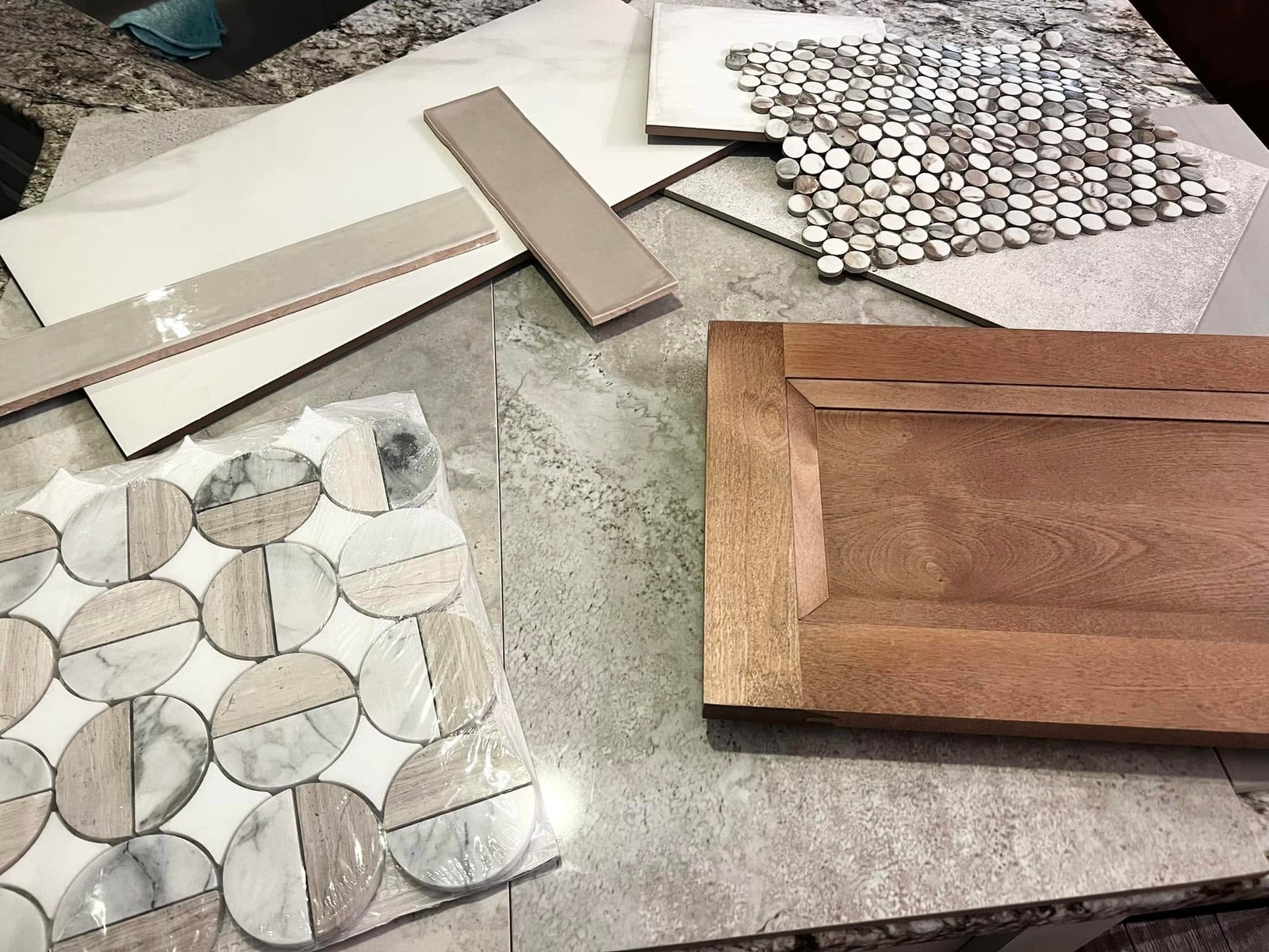 Interior design material selection featuring cabinet finishes, countertop samples, tile, and backsplash options for a custom kitchen renovation.